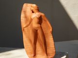 une petite sculpture représentant une femme debout sur une table