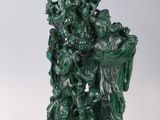 statue représentant un groupe de personnes sur un socle vert, avec un fond blanc