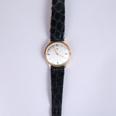 a close up of a watch on a white surface