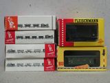 trois boîtes de petits trains miniatures posées les unes à côté des autres sur une table