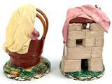 two figurines of a house and a bucket with a cloth on it