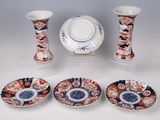 four different pieces of porcelain on display on a table