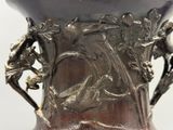 un vase en argent orné d'un oiseau et de fleurs