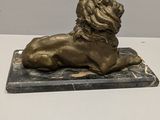 a bronze statue of a lion on a marble base