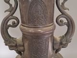 a silver vase that has two handles on it