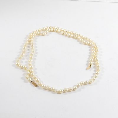 gros plan d'un collier de perles sur une surface blanche