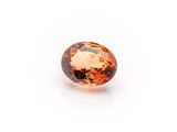 an oval faceted orange sapphire gems on a white background