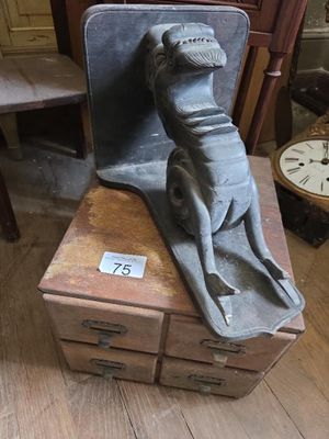 une statue représentant un chien assis sur une boîte