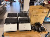 quatre imprimantes Canon posées sur une table dans un magasin