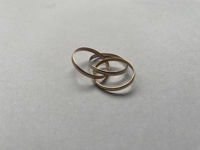 deux alliances en or sur une surface blanche