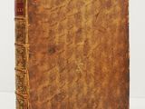 an old book sitting on top of a white surface