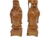 pair of carved wood figurines of a man and a woman holding a staff