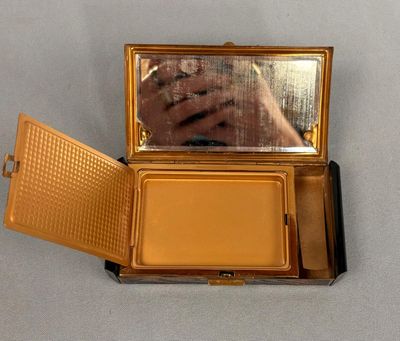 someone is taking a picture of their reflection in a compact mirror
