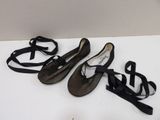 three pairs of black ballet shoes are lined up on a white surface