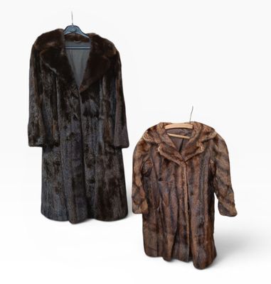 two fur coats on a hanger and a coat on a hanger