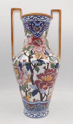 un vase muni d'une anse décorée de fleurs