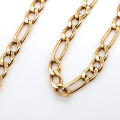 a close up of a gold chain on a white background