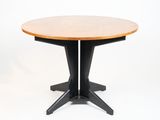 une table ronde en bois avec des pieds noirs et un plateau en bois