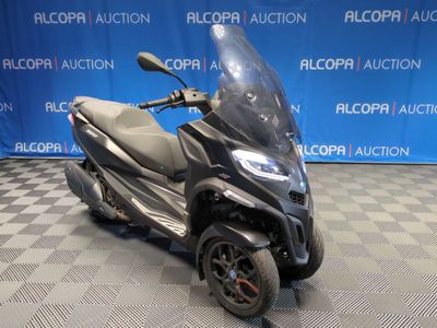 une photo d'un scooter garé sur un sol à damier
