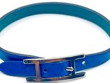 une ceinture en cuir bleu avec une boucle argentée sur fond blanc