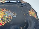 a black tray with a painting on it on a table