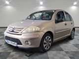 a picture of a small beige car parked in a garage