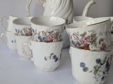 four cups and a pitcher sitting on a table