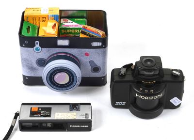 a camera, a camera case, and a cell phone on a table