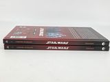 two star wars books are stacked on top of each other