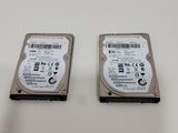 two hard drives sitting side by side on a white surface