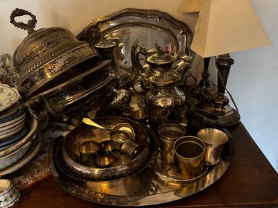 beaucoup d'argenterie sur une table sur laquelle est posée une lampe