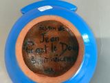 a blue vase with writing on it sitting on a table