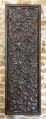 une plaque métallique fixée sur un mur de pierre, avec un mur de briques en arrière-plan