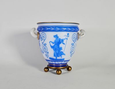 un vase bleu et blanc posé sur un socle, sur une surface blanche