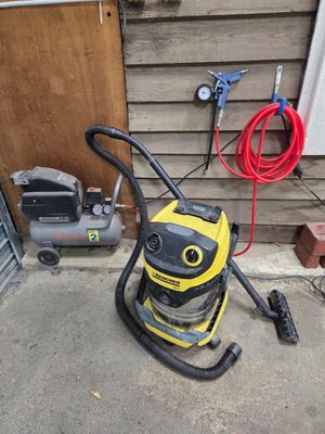 un aspirateur jaune et noir posé sur un sol en béton