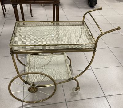 a glass and brass bar cart in the middle of a room