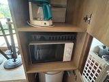 a small cabinet with a microwave and a coffee maker