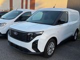 plusieurs fourgonnettes blanches garées sur un parking à côté d'un immeuble