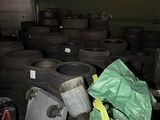 a pile of tires in a garage with a green bag on top