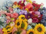 de nombreuses fleurs de différentes couleurs dans un vase posé sur la table