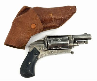 un vieux revolver dans un étui en cuir, posé sur une surface blanche