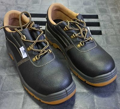 une paire de chaussures de travail en cuir noir avec des lacets jaunes sur la semelle