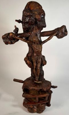 une image représentant une statue en bois d'un homme tenant une croix