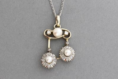 Chaine en or et son pendentif orné de perles et de diamants.