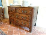 une commode en bois sur laquelle sont posées des assiettes, dans une pièce