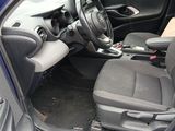 the interior of a car with the door open and the driver ' s seat down