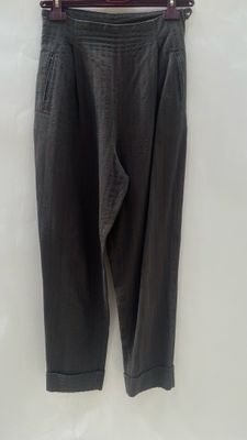 a black pants hanging on a hanger on a white wall