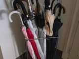 de nombreux parapluies posés dans un porte-parapluies en métal