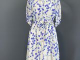 une robe à fleurs blanche et bleue posée sur un support de mannequin