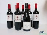 six bouteilles de vin rouge sont alignées sur une table